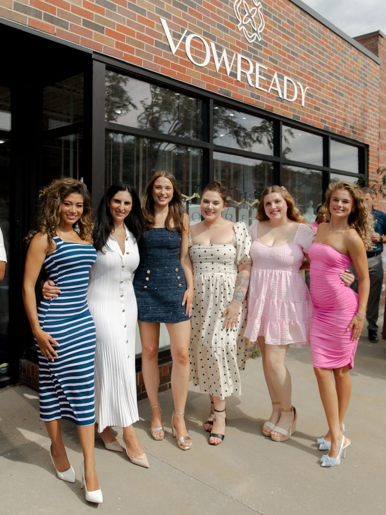 Guests posing together outside the Vow Ready North Kansas City storefront during the grand opening celebration.
