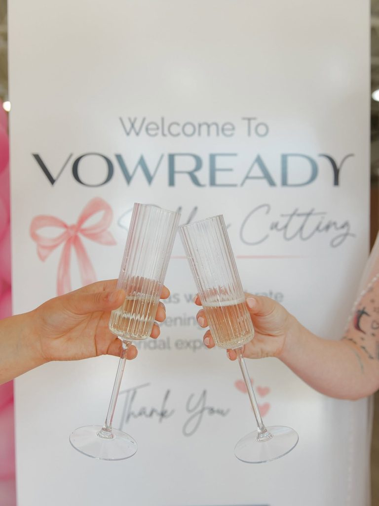 Guests raising champagne glasses to celebrate the Vow Ready North Kansas City grand opening and ribbon-cutting ceremony.
