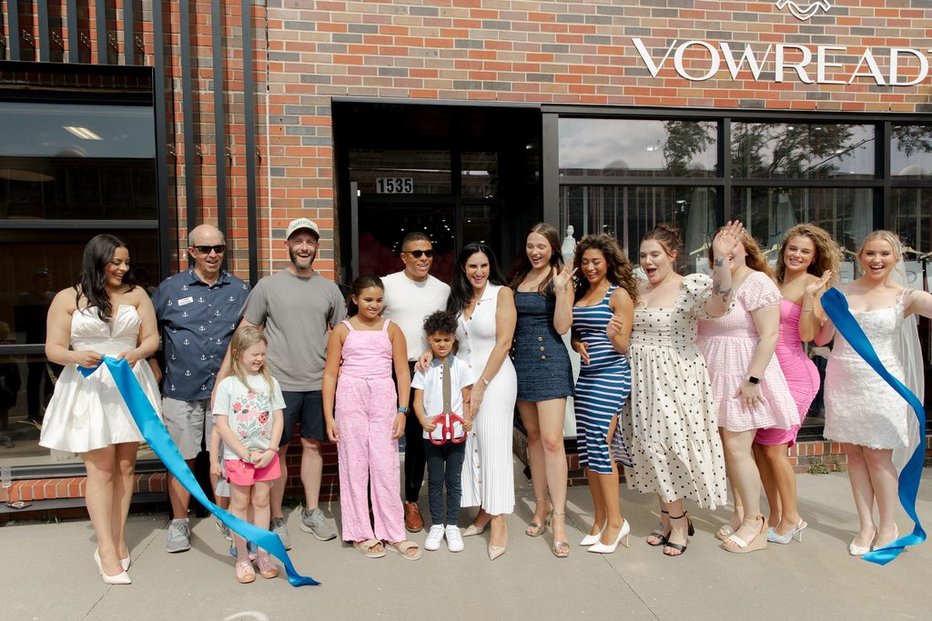 Vow Ready team, family, and community members celebrating the North Kansas City grand opening with a blue ribbon-cutting ceremony outside the store.